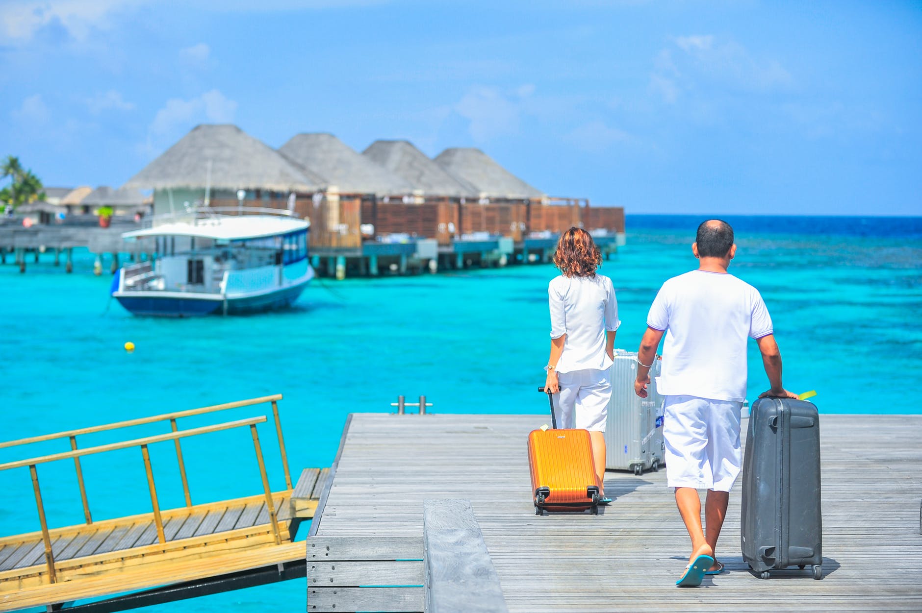 couple with baggage on platform in maldives