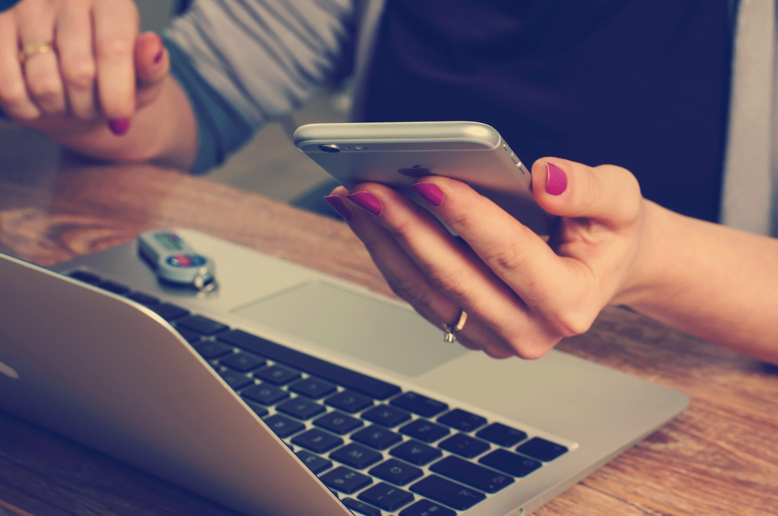 woman using laptop and mobile phone